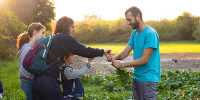 The Reboule farm producer sharing his harvest with a family - Photo credit: De beaux lents demains