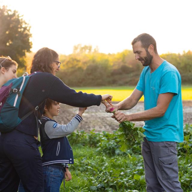 El agricultor de la granja Reboule compartiendo su cosecha con una familia - Crédito de la foto: De beaux lents demains