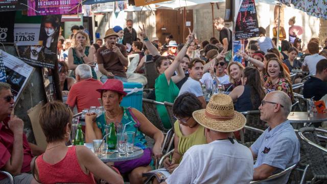 Festival-Atmosphäre mit Plakaten und Menschen auf der Terrasse - Bildnachweis: Frédéric Dahm / Empreintes d'Ailleurs