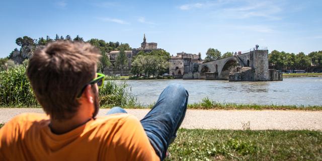 Garçon assis sur la Barthelasse face au Pont d'Avignon. Crédit : Frédéric Dahm / Empreintes d'Ailleurs