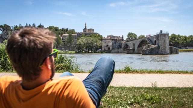 Garçon assis sur la Barthelasse face au Pont d'Avignon. Crédit : Frédéric Dahm / Empreintes d'Ailleurs