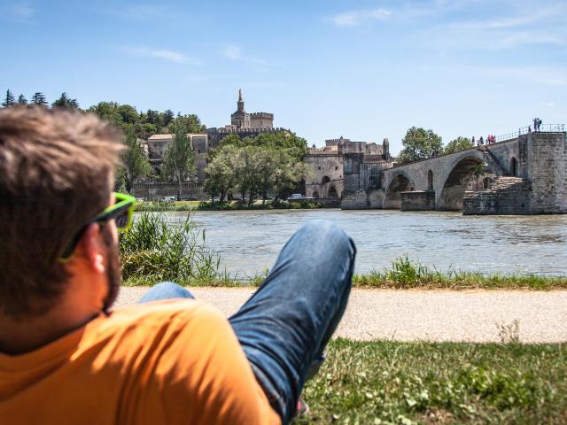 Garçon assis sur la Barthelasse face au Pont d'Avignon. Crédit : Frédéric Dahm / Empreintes d'Ailleurs