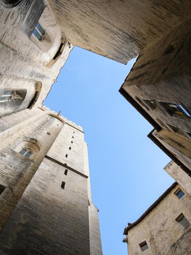 Contre-plongée sur le Palais des Papes, rue de la Peyrolerie